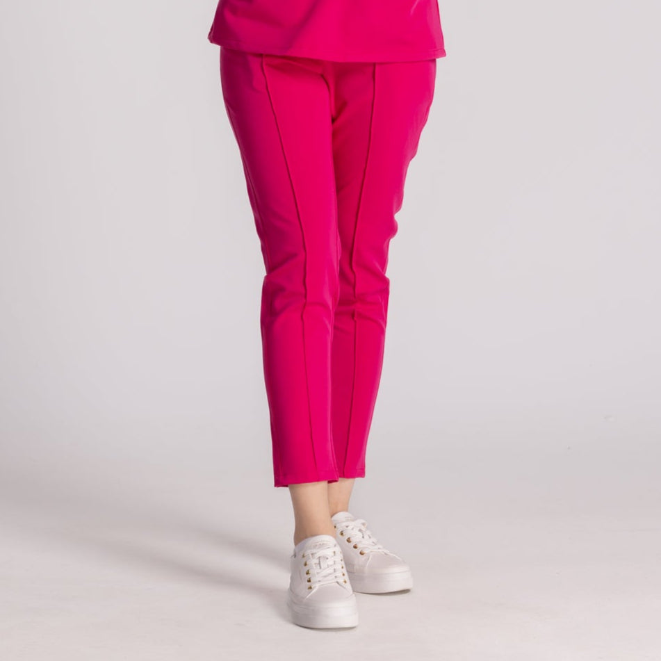 Pantaloni Medicali Elastici Elise în culoare roz, combinați cu pantofi sport albi, oferind stil și confort.