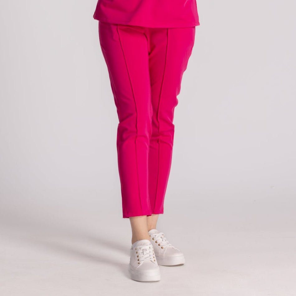 Pantaloni Medicali Elastici Elise în culoare roz, combinați cu pantofi sport albi, oferind stil și confort.