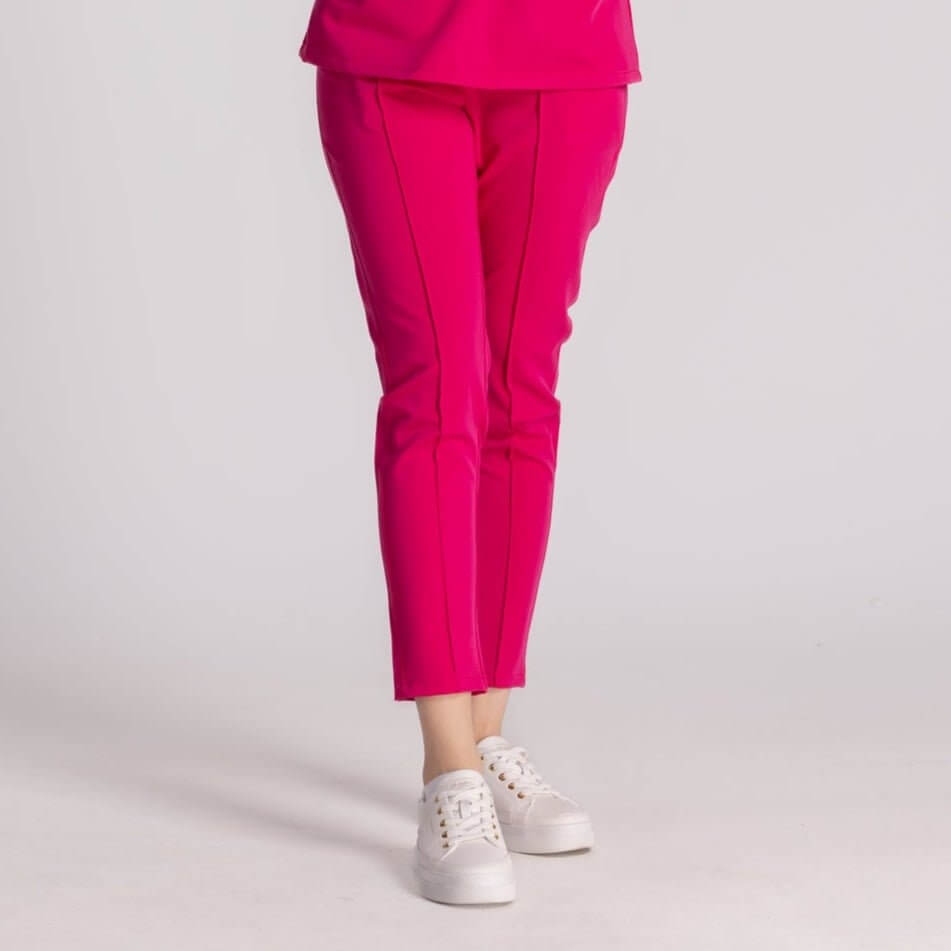 Pantaloni Medicali Elastici Elise în culoare roz, combinați cu pantofi sport albi, oferind stil și confort.
