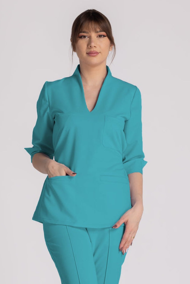 Bluza Elastica Elise - bluză medicală elegantă, cu guler shal și buzunare prietenoase, în nuanță turcoaz.